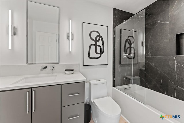 full bathroom featuring toilet, vanity, and tiled shower / bath