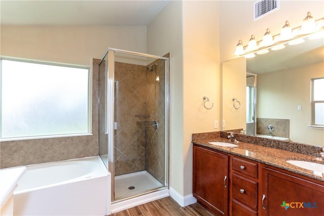 bathroom with a wealth of natural light, hardwood / wood-style floors, vanity, and lofted ceiling