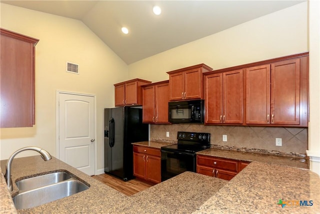 kitchen with black appliances, sink, light hardwood / wood-style flooring, decorative backsplash, and light stone counters