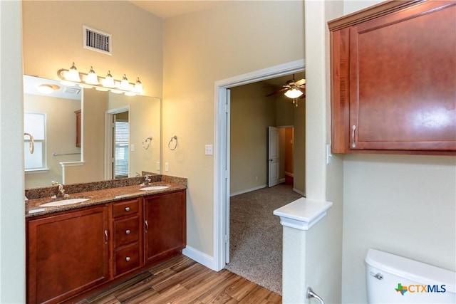 bathroom featuring ceiling fan, vanity, wood-type flooring, and toilet