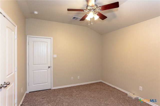 carpeted empty room featuring vaulted ceiling and ceiling fan