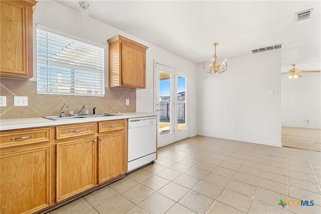 kitchen with pendant lighting, dishwasher, sink, light tile patterned floors, and tasteful backsplash