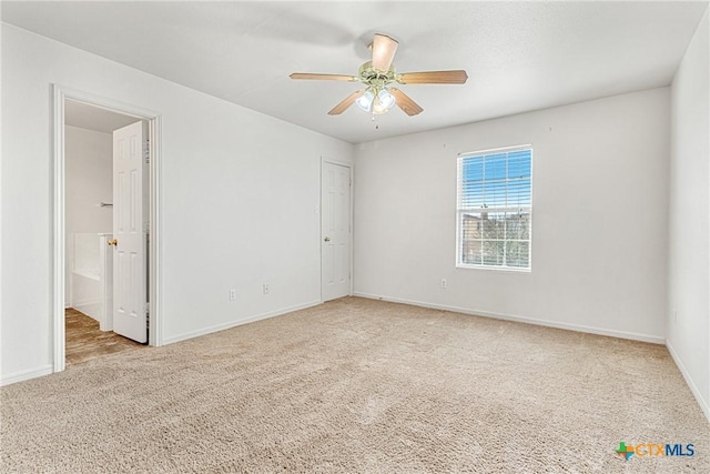 spare room featuring ceiling fan and light carpet