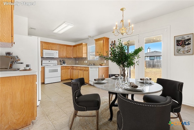 kitchen with decorative backsplash, white appliances, light tile patterned floors, a chandelier, and hanging light fixtures