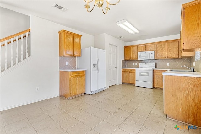 kitchen with tasteful backsplash, sink, white appliances, and a notable chandelier