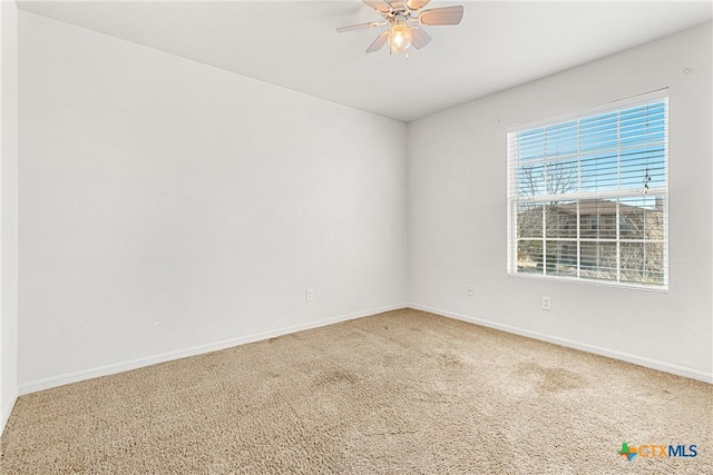 carpeted spare room featuring ceiling fan