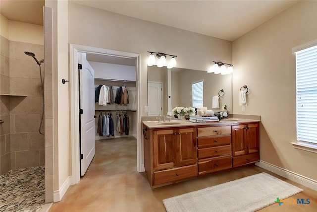 full bath featuring plenty of natural light, tiled shower, and a sink