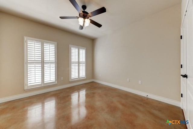 empty room featuring ceiling fan, baseboards, and finished concrete flooring