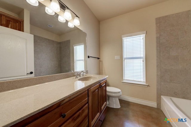 bathroom featuring baseboards, toilet, a healthy amount of sunlight, and vanity