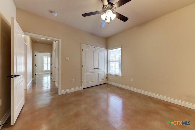 unfurnished bedroom featuring multiple windows, baseboards, and concrete floors