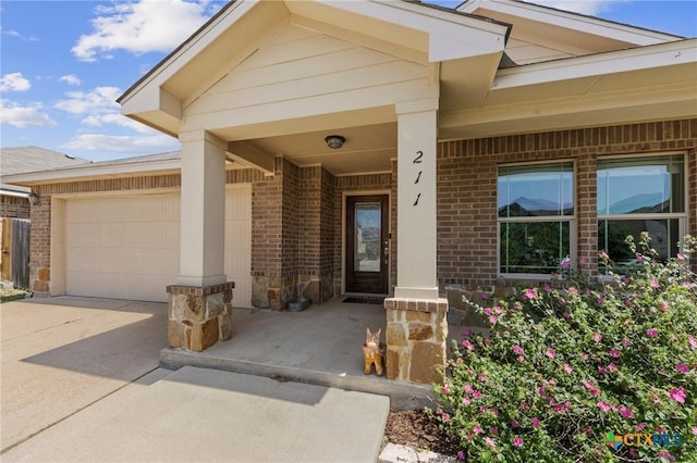 211 W Vega Ln, Killeen, TX 76542 - doorway to property featuring brick siding, driveway, an attached garage, and covered porch