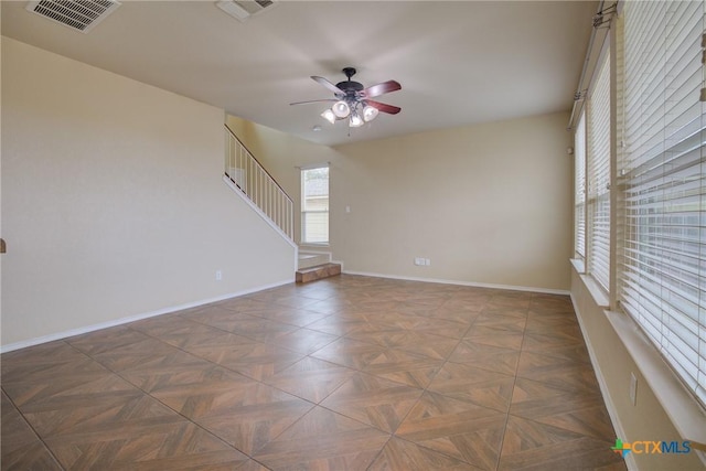 unfurnished room featuring ceiling fan and dark parquet flooring