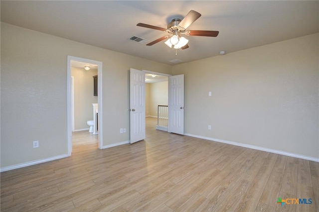 525 Tom Kemp Dr, New Braunfels, TX 78130 - unfurnished bedroom with light wood finished floors, connected bathroom, and a ceiling fan