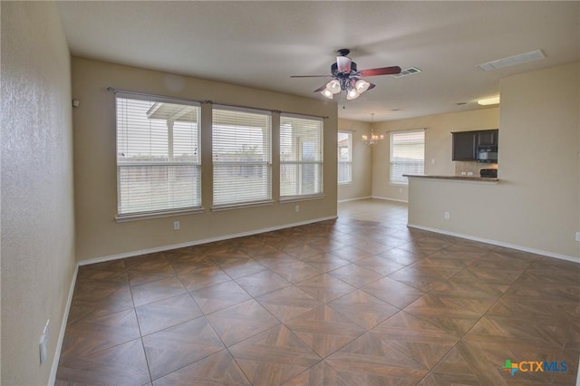 empty room with ceiling fan with notable chandelier