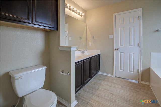 bathroom featuring hardwood / wood-style floors, vanity, and toilet