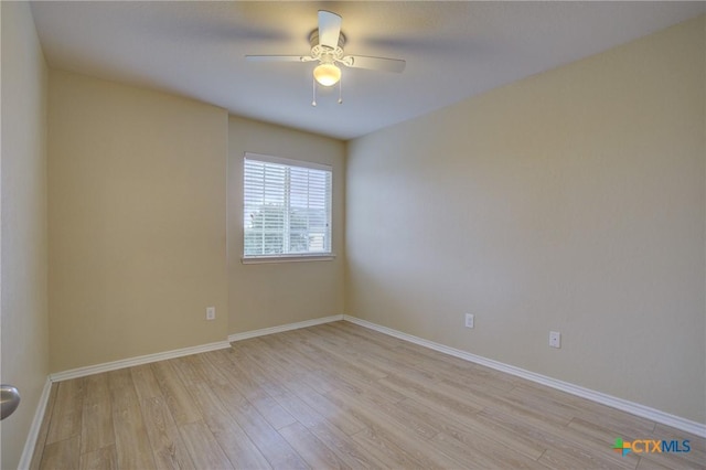 empty room with ceiling fan and light hardwood / wood-style flooring