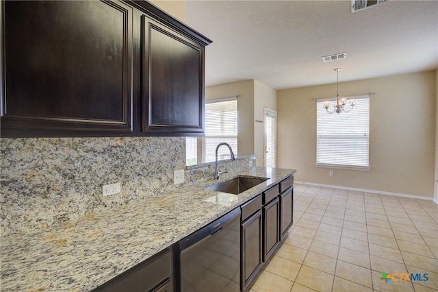 525 Tom Kemp Dr, New Braunfels, TX 78130 - kitchen featuring dark brown cabinets, a sink, a notable chandelier, light stone countertops, and dishwashing machine