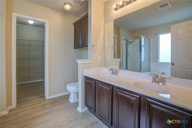 525 Tom Kemp Dr, New Braunfels, TX 78130 - full bathroom featuring a shower stall, wood finished floors, double vanity, and a walk in closet