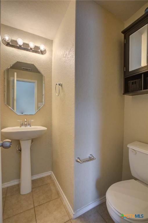 bathroom with tile patterned flooring, toilet, and sink