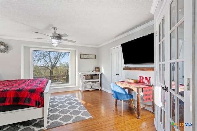 bedroom featuring ceiling fan, crown molding, wood-type flooring, and a textured ceiling