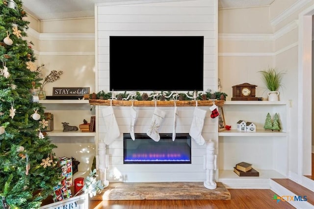 interior details with built in shelves, hardwood / wood-style floors, and a textured ceiling