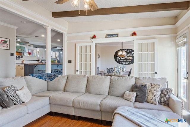 living room with beamed ceiling, hardwood / wood-style flooring, and ceiling fan