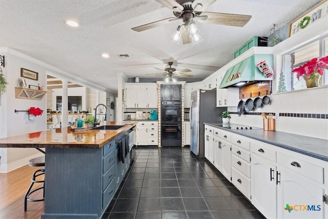 kitchen with white cabinetry, sink, and a textured ceiling