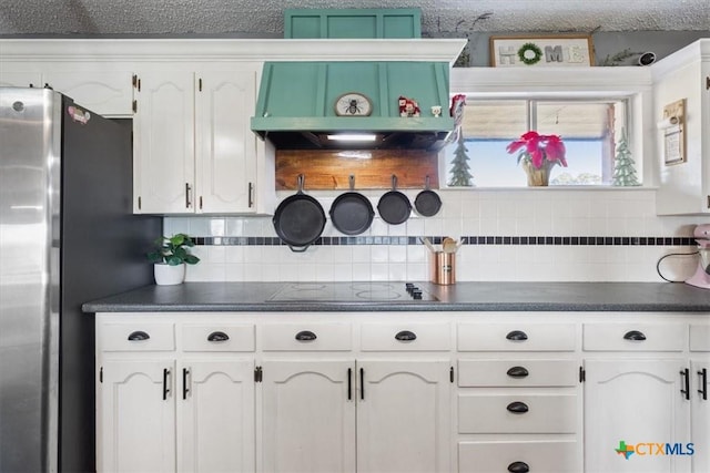 kitchen featuring tasteful backsplash, white cabinetry, and electric stovetop