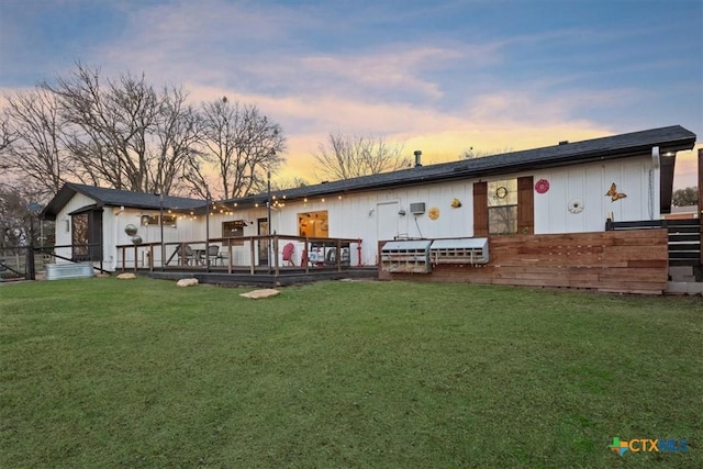 back house at dusk featuring a yard