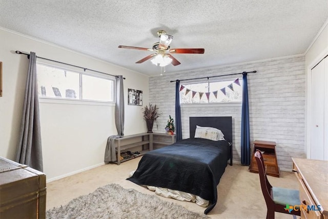 carpeted bedroom featuring ceiling fan, crown molding, and a textured ceiling