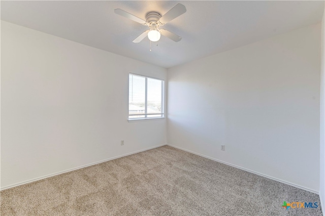 spare room with ceiling fan and light carpet