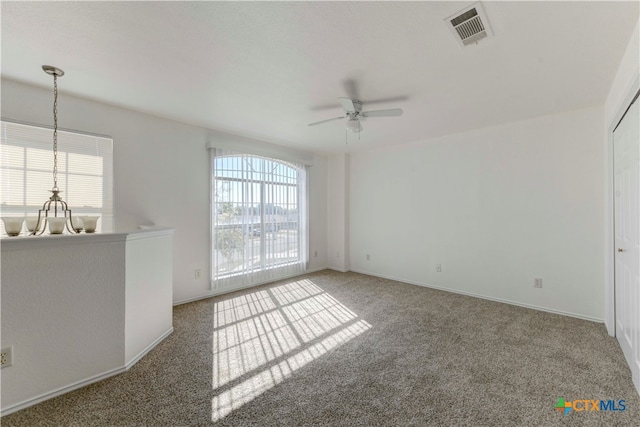 spare room featuring dark carpet, plenty of natural light, and ceiling fan