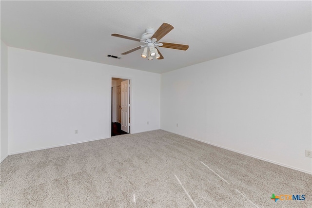 carpeted spare room featuring ceiling fan