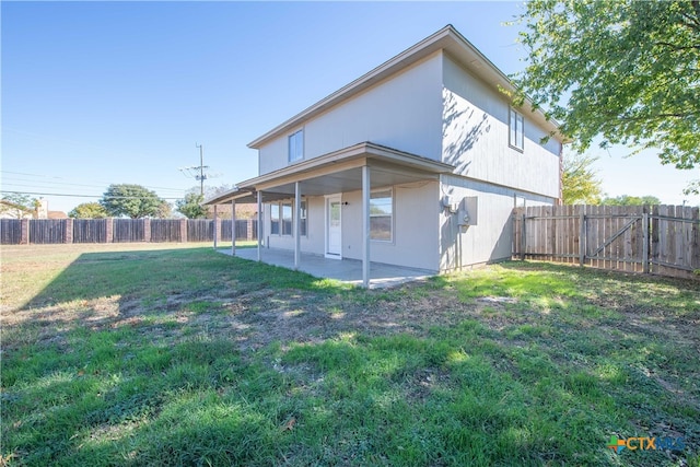 back of house featuring a patio area and a yard