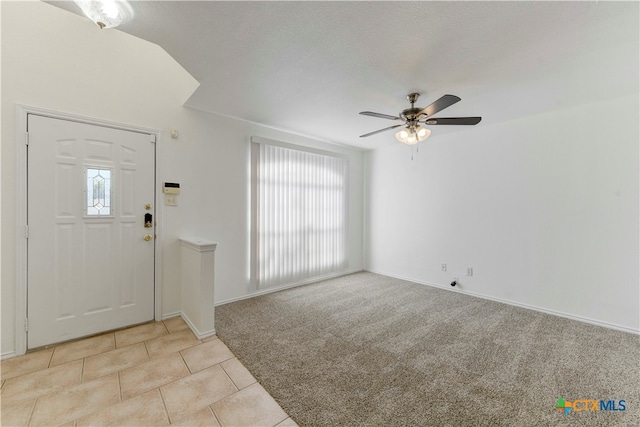 carpeted foyer with a textured ceiling and ceiling fan