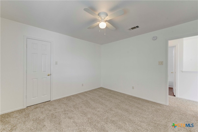 spare room featuring ceiling fan and light colored carpet