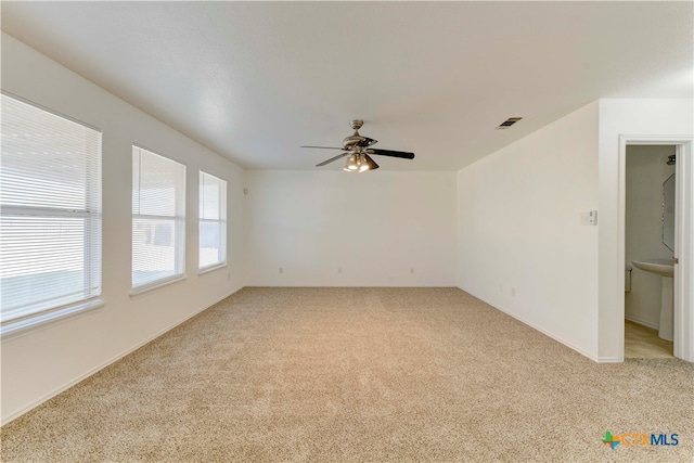 carpeted spare room with ceiling fan