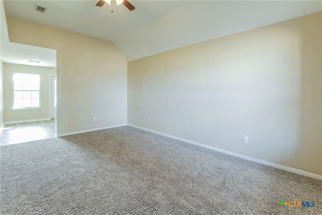 spare room featuring carpet, ceiling fan, and vaulted ceiling