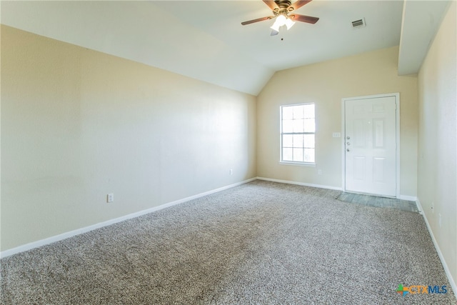 carpeted spare room with ceiling fan and vaulted ceiling