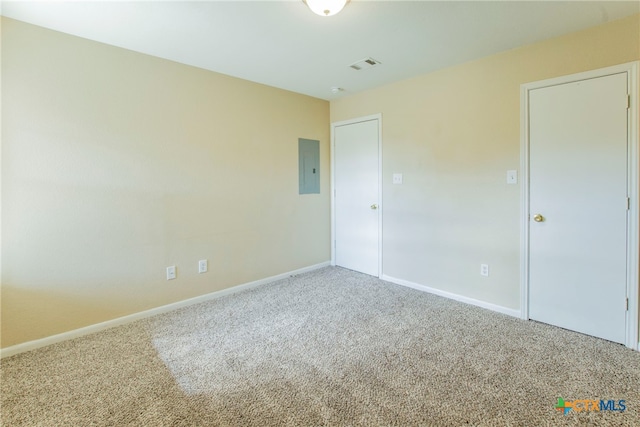 unfurnished room featuring electric panel and carpet