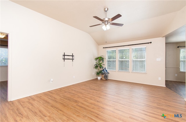 spare room with ceiling fan, light wood-type flooring, and vaulted ceiling