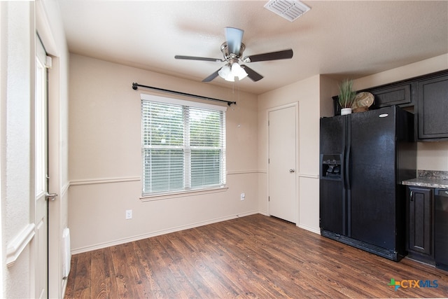 kitchen featuring dark hardwood / wood-style flooring, black fridge, and ceiling fan