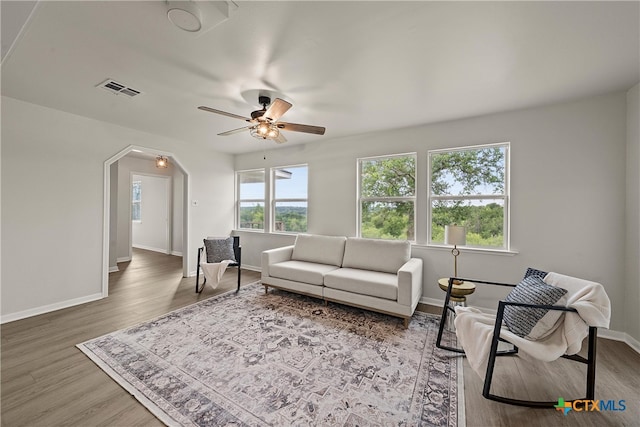 living room with baseboards, ceiling fan, visible vents, and wood finished floors