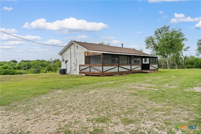 rear view of property with a sunroom and a yard