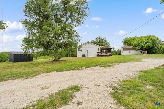 view of yard with a deck and an outbuilding