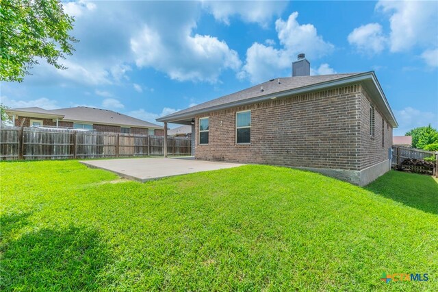 8530 Lamplight Ct, Temple, TX 76502 - rear view of house with a patio area, brick siding, a fenced backyard, and a chimney
