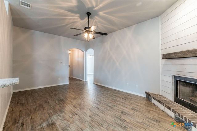 8530 Lamplight Ct, Temple, TX 76502 - unfurnished living room featuring arched walkways, a ceiling fan, wood finished floors, and a fireplace