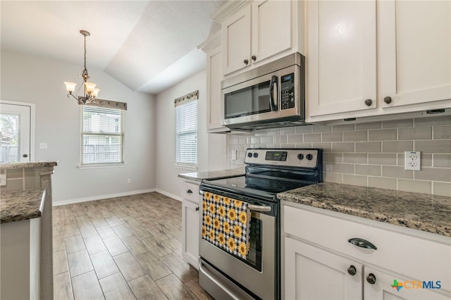8530 Lamplight Ct, Temple, TX 76502 - kitchen with stainless steel appliances, vaulted ceiling, backsplash, a chandelier, and light stone counters