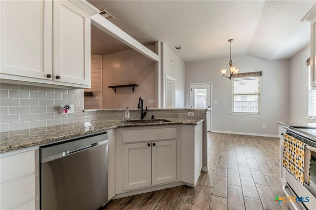 8530 Lamplight Ct, Temple, TX 76502 - kitchen with appliances with stainless steel finishes, a peninsula, backsplash, a chandelier, and white cabinetry