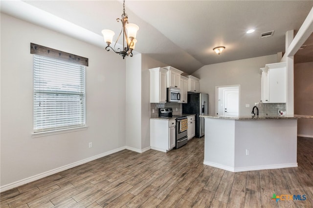 8530 Lamplight Ct, Temple, TX 76502 - kitchen featuring appliances with stainless steel finishes, tasteful backsplash, a chandelier, white cabinets, and wood finished floors